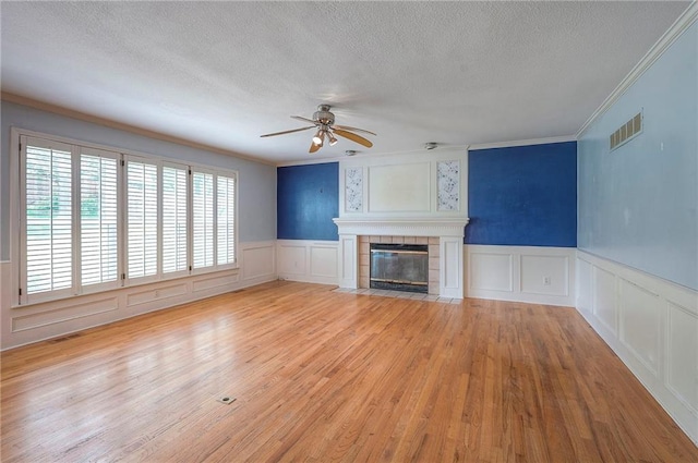 9705 N Virginia Ave, Kansas City, MO 64155 - unfurnished living room with a textured ceiling, ornamental molding, a ceiling fan, a decorative wall, and a fireplace
