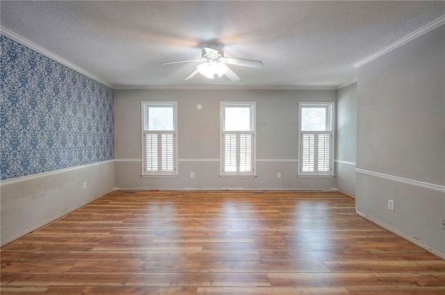 9705 N Virginia Ave, Kansas City, MO 64155 - unfurnished room with ceiling fan, a textured ceiling, hardwood / wood-style floors, wallpapered walls, and crown molding