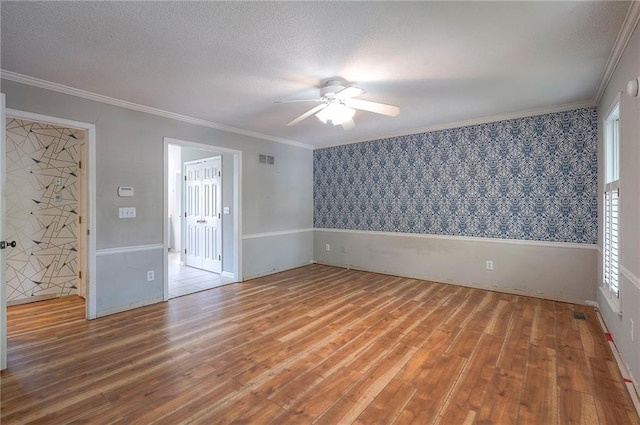 9705 N Virginia Ave, Kansas City, MO 64155 - unfurnished room featuring wallpapered walls, wood finished floors, ceiling fan, ornamental molding, and a textured ceiling