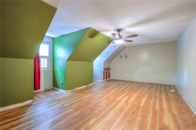 9705 N Virginia Ave, Kansas City, MO 64155 - additional living space featuring ceiling fan, vaulted ceiling, wood-type flooring, and a textured ceiling