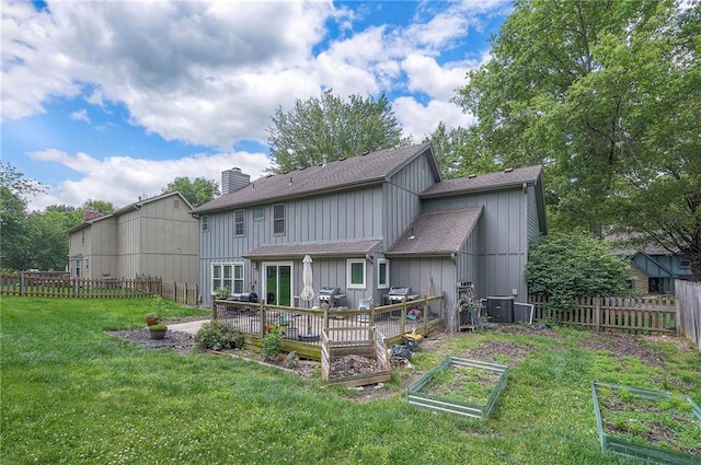 9705 N Virginia Ave, Kansas City, MO 64155 - back of property with a vegetable garden, roof with shingles, a fenced backyard, a chimney, and board and batten siding