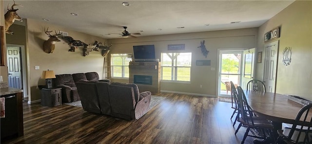 3632 SE 228th St, Lathrop, MO 64465 - living room featuring a glass covered fireplace, dark wood-type flooring, a ceiling fan, and healthy amount of natural light