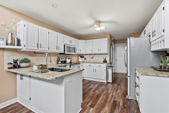 6809 W 156th St, Overland Park, KS 66223 - kitchen featuring stainless steel appliances, a peninsula, dark wood-type flooring, light stone countertops, and white cabinets