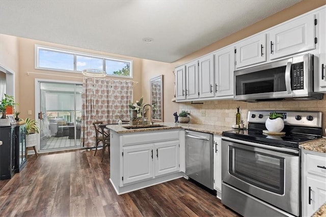 6809 W 156th St, Overland Park, KS 66223 - kitchen with appliances with stainless steel finishes, a peninsula, white cabinets, and light stone countertops