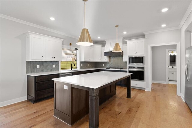 3113 SW Arboridge Dr, Lees Summit, MO 64081 - kitchen featuring appliances with stainless steel finishes, white cabinets, ornamental molding, light countertops, and light wood finished floors