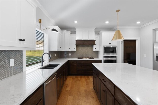 3113 SW Arboridge Dr, Lees Summit, MO 64081 - kitchen with appliances with stainless steel finishes, crown molding, light wood-style floors, white cabinets, and dark brown cabinets