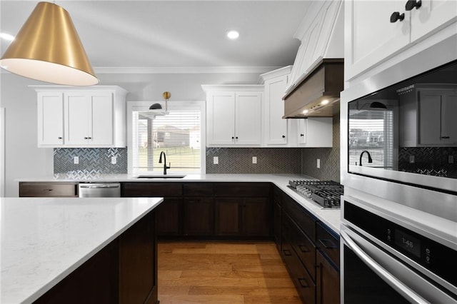 3113 SW Arboridge Dr, Lees Summit, MO 64081 - kitchen with appliances with stainless steel finishes, light wood-style flooring, crown molding, white cabinetry, and backsplash