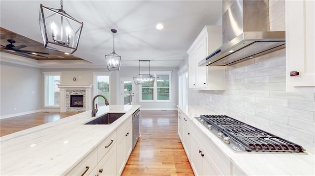 22902 S Ridgeview Dr, Peculiar, MO 64078 - kitchen with wall chimney range hood, stainless steel appliances, light wood-type flooring, a chandelier, and recessed lighting