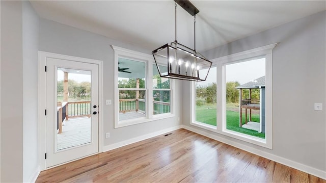 22902 S Ridgeview Dr, Peculiar, MO 64078 - unfurnished dining area featuring a chandelier, healthy amount of natural light, and wood finished floors