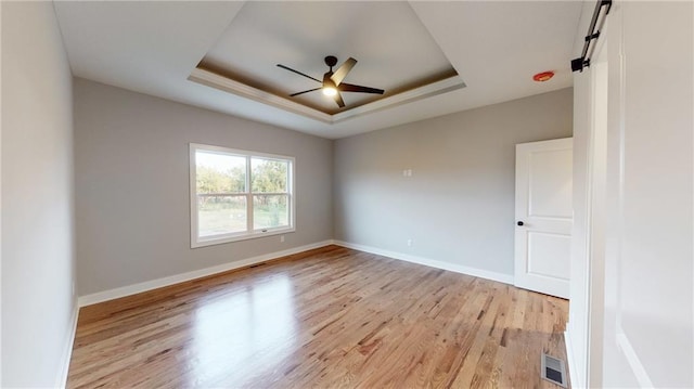 22902 S Ridgeview Dr, Peculiar, MO 64078 - unfurnished room featuring a raised ceiling, light wood-style floors, and a ceiling fan