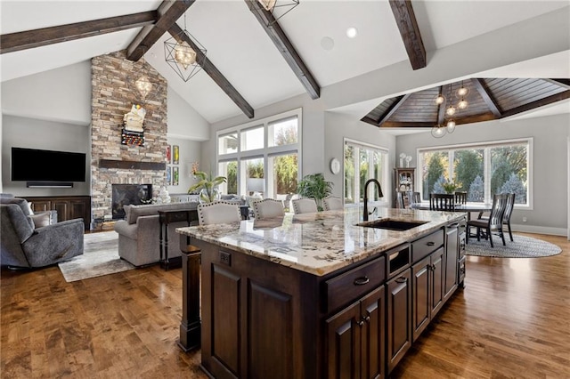 14713 Ash St, Leawood, KS 66224 - kitchen featuring beamed ceiling, dark wood-style flooring, light stone counters, healthy amount of natural light, and high vaulted ceiling