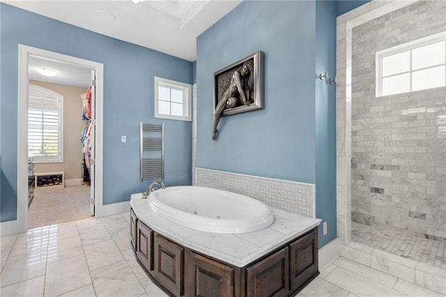 14713 Ash St, Leawood, KS 66224 - bathroom featuring a jetted tub, marble look tile flooring, tiled shower, and a towel warming rack