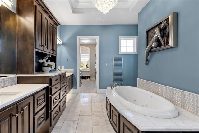 14713 Ash St, Leawood, KS 66224 - bathroom with a tub with jets, marble finish floors, heating unit, a chandelier, and vanity