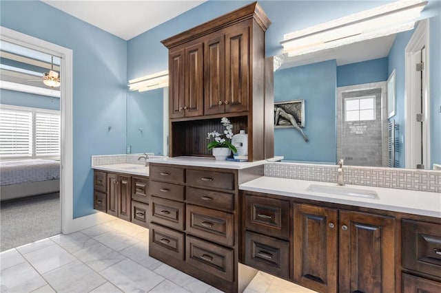 14713 Ash St, Leawood, KS 66224 - ensuite bathroom featuring double vanity, ceiling fan, marble finish floors, and backsplash