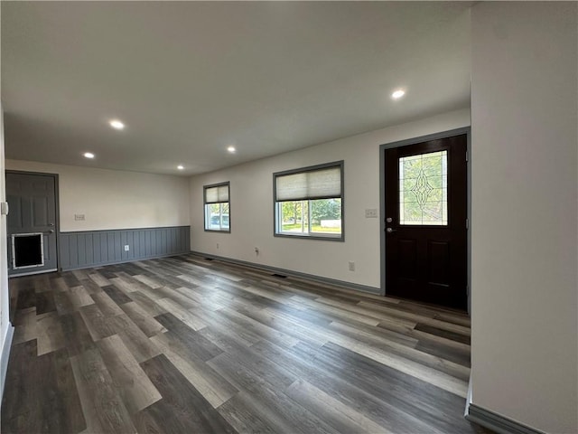 1915 W 5th St, Sedalia, MO 65301 - unfurnished living room with dark wood finished floors, recessed lighting, and a wainscoted wall
