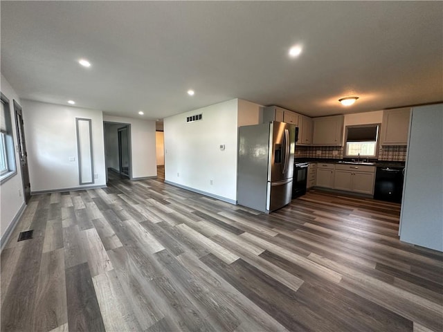 1915 W 5th St, Sedalia, MO 65301 - kitchen featuring stainless steel fridge with ice dispenser, open floor plan, black dishwasher, dark countertops, and dark wood-style floors