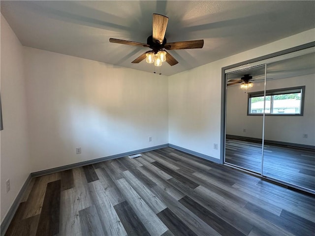1915 W 5th St, Sedalia, MO 65301 - unfurnished bedroom with dark wood finished floors, a closet, and ceiling fan