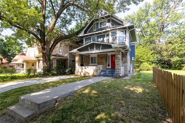 3428 College Ave, Kansas City, MO 64128 - victorian home featuring stone siding and a porch