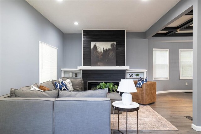 3428 College Ave, Kansas City, MO 64128 - living area with wood finished floors, recessed lighting, a large fireplace, and beamed ceiling