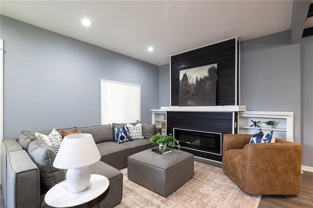 3428 College Ave, Kansas City, MO 64128 - living area featuring wood finished floors, recessed lighting, and a glass covered fireplace
