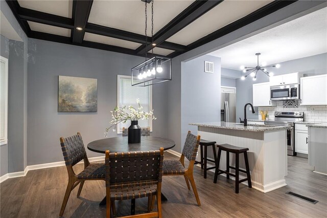 3428 College Ave, Kansas City, MO 64128 - dining room featuring a chandelier, dark wood-style flooring, beamed ceiling, and coffered ceiling