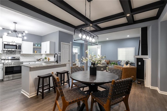 3428 College Ave, Kansas City, MO 64128 - dining space with dark wood finished floors, beamed ceiling, coffered ceiling, and recessed lighting