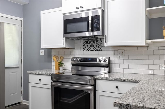 3428 College Ave, Kansas City, MO 64128 - kitchen with stainless steel appliances, white cabinets, and tasteful backsplash