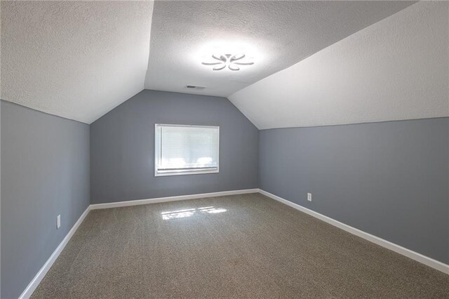 3428 College Ave, Kansas City, MO 64128 - bonus room featuring a textured ceiling, carpet, and lofted ceiling