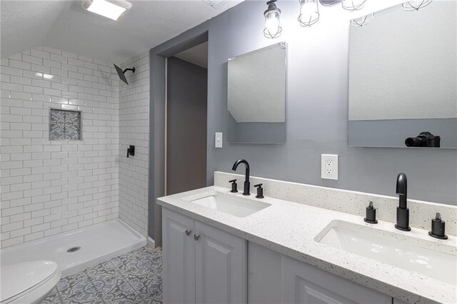 3428 College Ave, Kansas City, MO 64128 - full bathroom featuring tiled shower, double vanity, and vaulted ceiling
