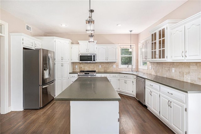 4824 W 162nd St, Overland Park, KS 66085 - kitchen featuring stainless steel appliances, dark countertops, white cabinets, glass insert cabinets, and recessed lighting