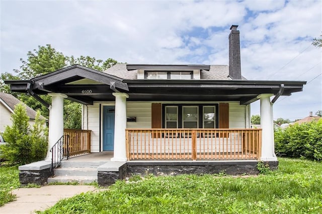 4600 Chestnut Ave, Kansas City, MO 64130 - view of front facade featuring covered porch, a chimney, and roof with shingles