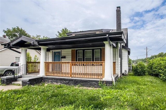 4600 Chestnut Ave, Kansas City, MO 64130 - view of front facade featuring covered porch and a chimney