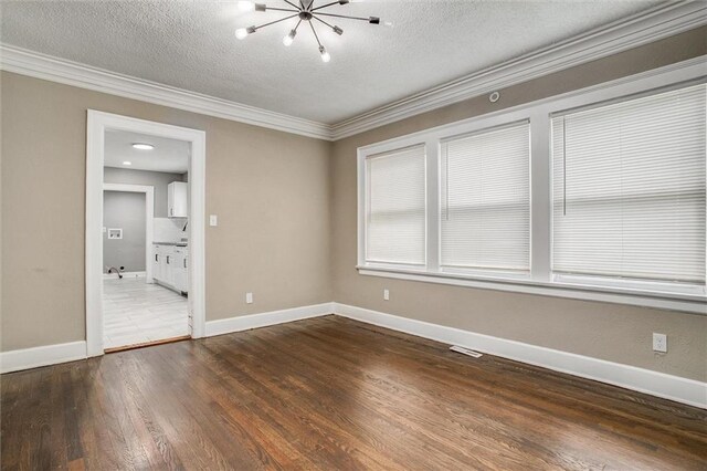 4600 Chestnut Ave, Kansas City, MO 64130 - unfurnished room with crown molding, a textured ceiling, a chandelier, and wood finished floors