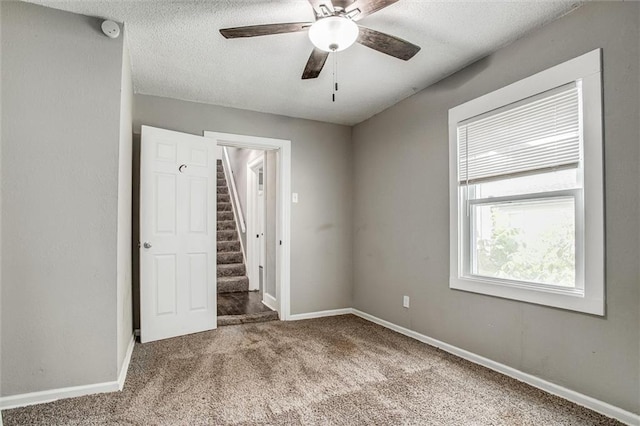4600 Chestnut Ave, Kansas City, MO 64130 - unfurnished bedroom with carpet floors, a textured ceiling, and ceiling fan