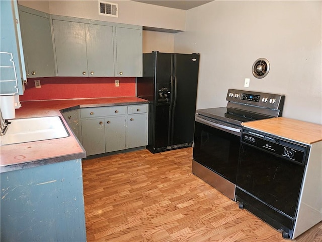 1419 W College Ter, Independence, MO 64050 - kitchen featuring black appliances, light wood finished floors, and gray cabinetry