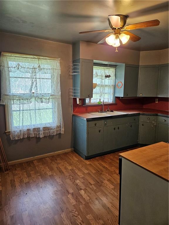 1419 W College Ter, Independence, MO 64050 - kitchen with plenty of natural light, a ceiling fan, gray cabinets, and wood finished floors