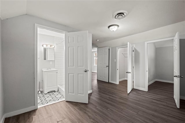 520 Sandusky Ave, Kansas City, KS 66101 - unfurnished bedroom featuring dark wood-style flooring, vaulted ceiling, and connected bathroom