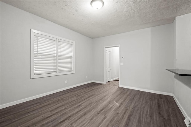 520 Sandusky Ave, Kansas City, KS 66101 - spare room with a textured ceiling and dark wood-type flooring
