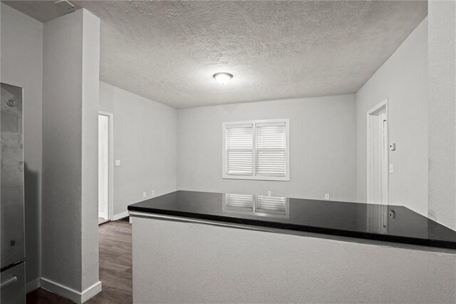 520 Sandusky Ave, Kansas City, KS 66101 - kitchen featuring dark wood-style flooring, a textured ceiling, and dark countertops
