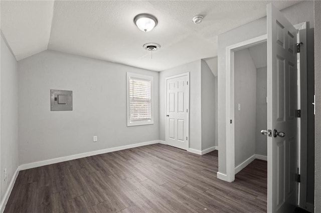 520 Sandusky Ave, Kansas City, KS 66101 - unfurnished bedroom featuring electric panel, dark wood-type flooring, lofted ceiling, a closet, and a textured ceiling