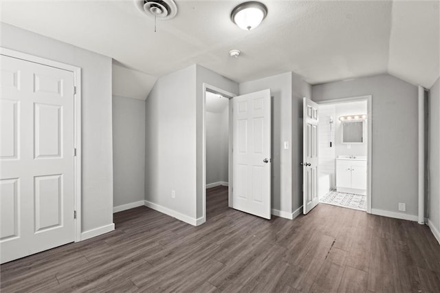 520 Sandusky Ave, Kansas City, KS 66101 - unfurnished bedroom with dark wood finished floors, vaulted ceiling, and ensuite bathroom