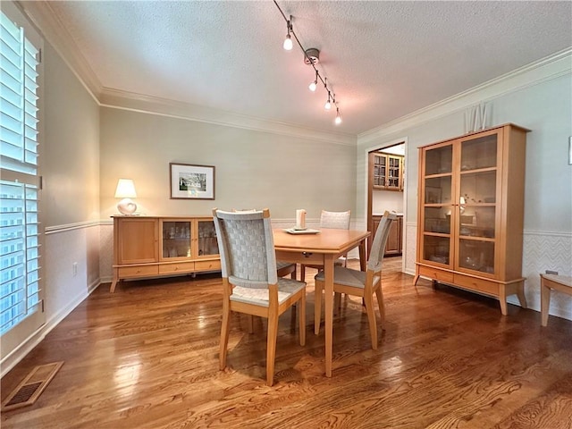 4117 NE Edgewater Ct, Lees Summit, MO 64064 - dining space with a textured ceiling, wood finished floors, ornamental molding, and rail lighting