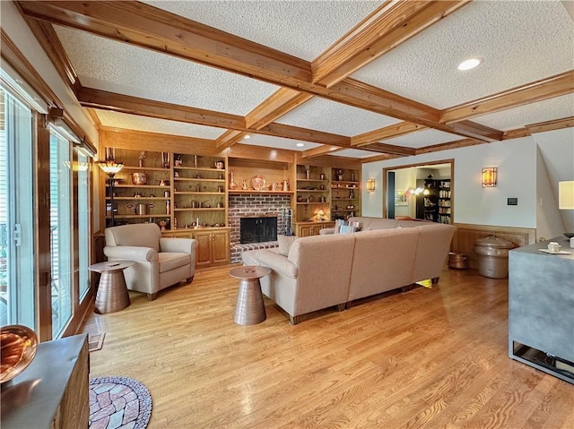 4117 NE Edgewater Ct, Lees Summit, MO 64064 - living area featuring a textured ceiling, beamed ceiling, coffered ceiling, light wood-style floors, and built in shelves