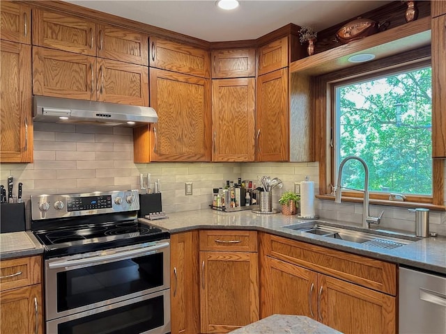4117 NE Edgewater Ct, Lees Summit, MO 64064 - kitchen featuring appliances with stainless steel finishes, under cabinet range hood, decorative backsplash, and brown cabinets