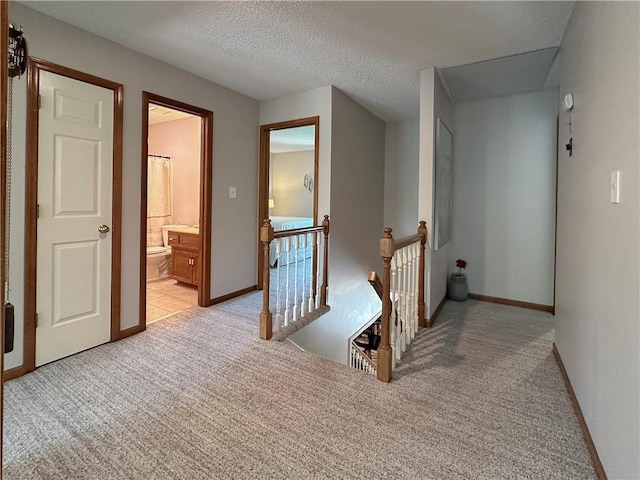 4117 NE Edgewater Ct, Lees Summit, MO 64064 - hall featuring an upstairs landing, light carpet, and a textured ceiling