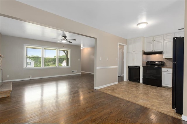 1219 W 35th St, Independence, MO 64055 - kitchen featuring black appliances, under cabinet range hood, white cabinetry, ceiling fan, and open floor plan