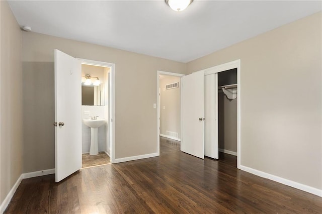 1219 W 35th St, Independence, MO 64055 - unfurnished bedroom with dark wood finished floors, a closet, and ensuite bathroom