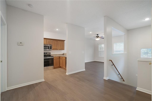 461 S Woodson Ln, Gardner, KS 66030 - kitchen with appliances with stainless steel finishes, wood finished floors, a ceiling fan, recessed lighting, and light countertops