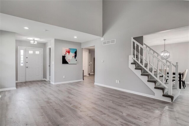 12321 W 105th Ter, Overland Park, KS 66215 - foyer featuring a chandelier, stairs, wood finished floors, recessed lighting, and a high ceiling