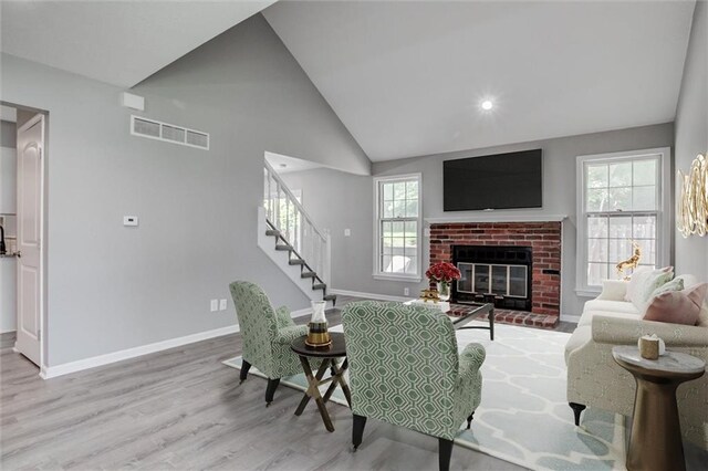 12321 W 105th Ter, Overland Park, KS 66215 - living room featuring plenty of natural light, wood finished floors, vaulted ceiling, stairway, and a fireplace